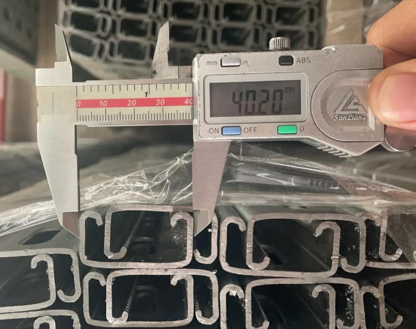Quality inspection of stamped metal bracket — dimensional measurement with caliper
