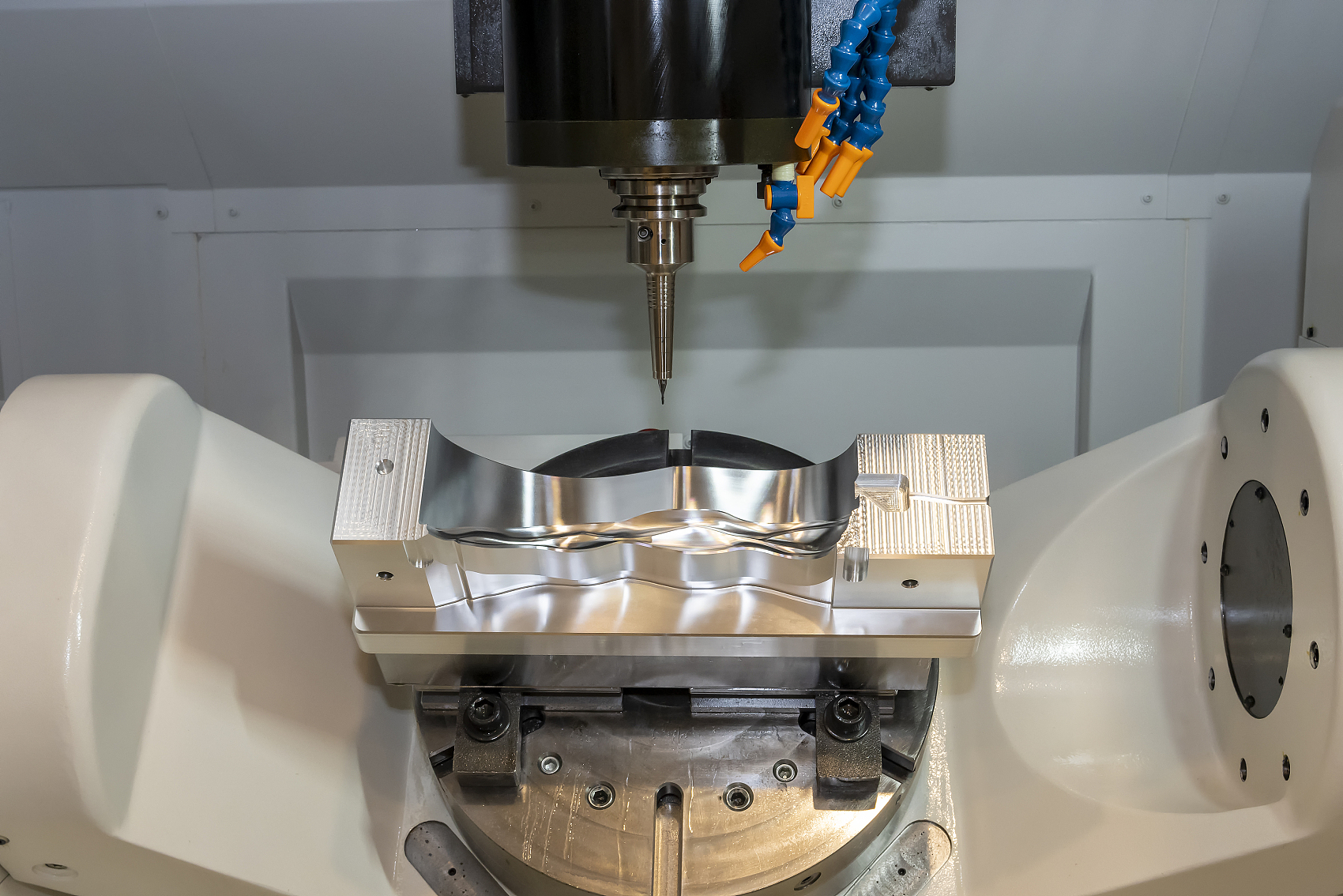 Magnesium die cast part being CNC machined on a 5-axis machining center