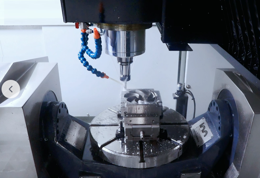 5-axis CNC machining center cutting a metal component under coolant for tight-tolerance production