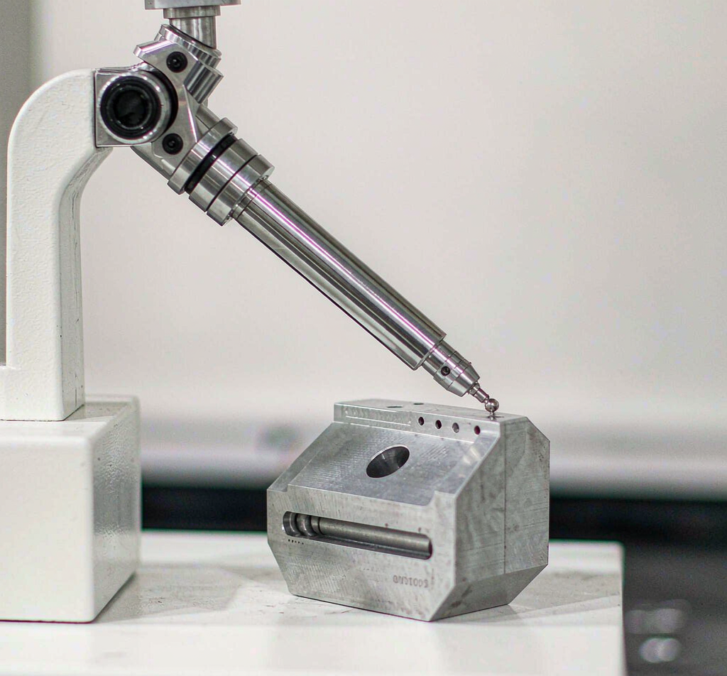 CMM probe inspecting a precision machined aluminum component