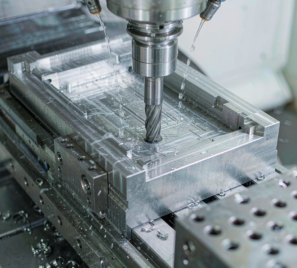 End mill cutting a pocket in a silver 6061 aluminium block inside a CNC machining centre with coolant and chips