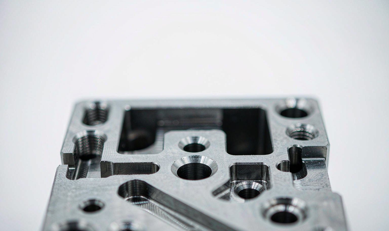 Close-up of machined holes, slots and threads on a metal component