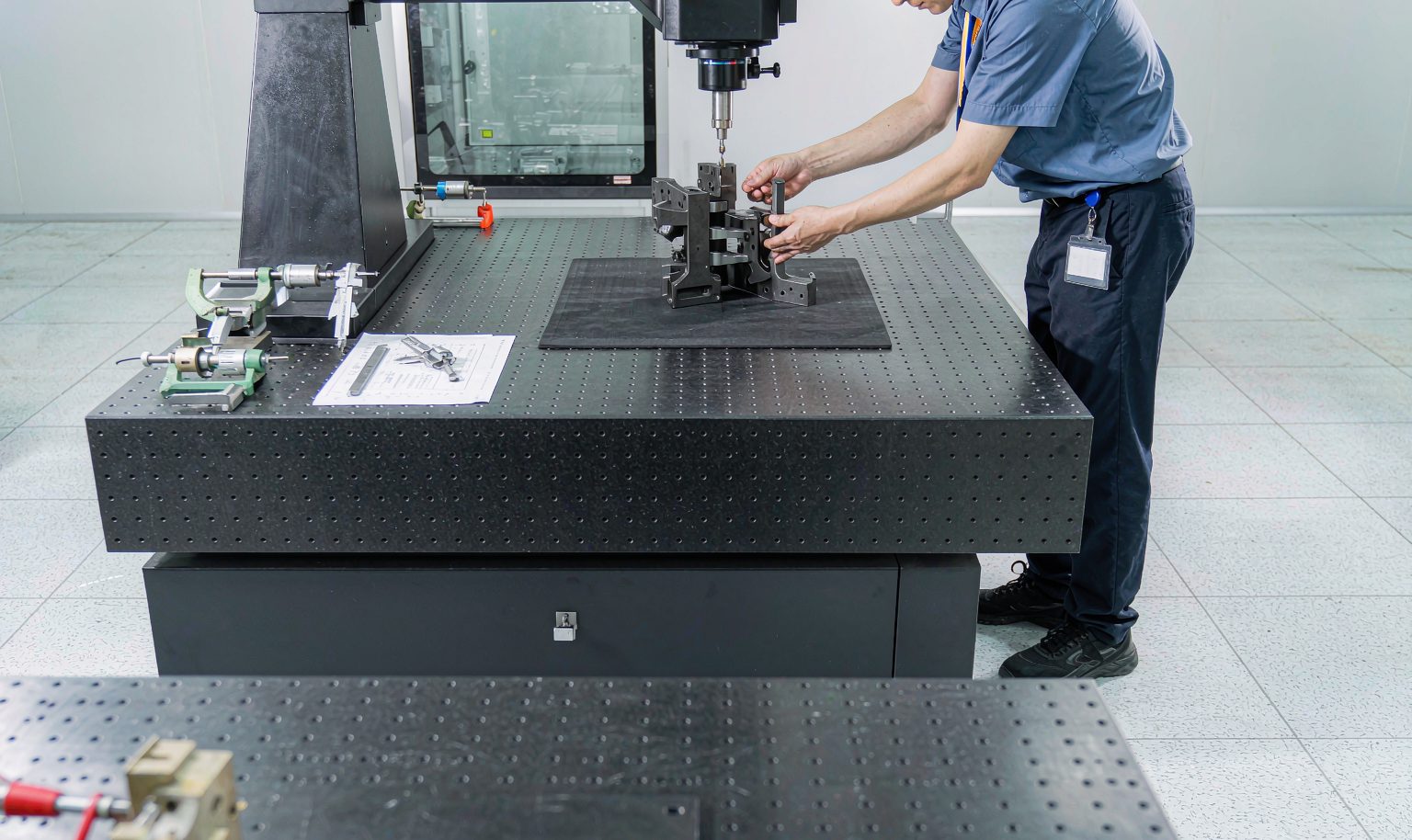Coordinate measuring machine measuring a metal part in a temperature-controlled metrology room