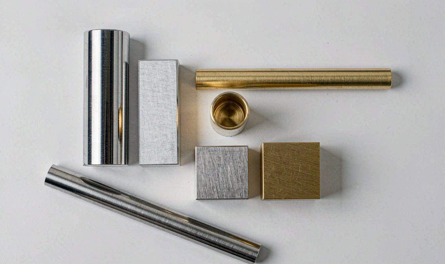 Raw aluminum, stainless steel and brass bar stock prepared for CNC machining