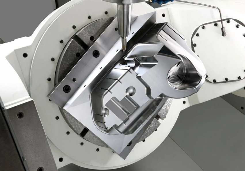 CNC machining centre performing precision milling on a small aluminum prototype part