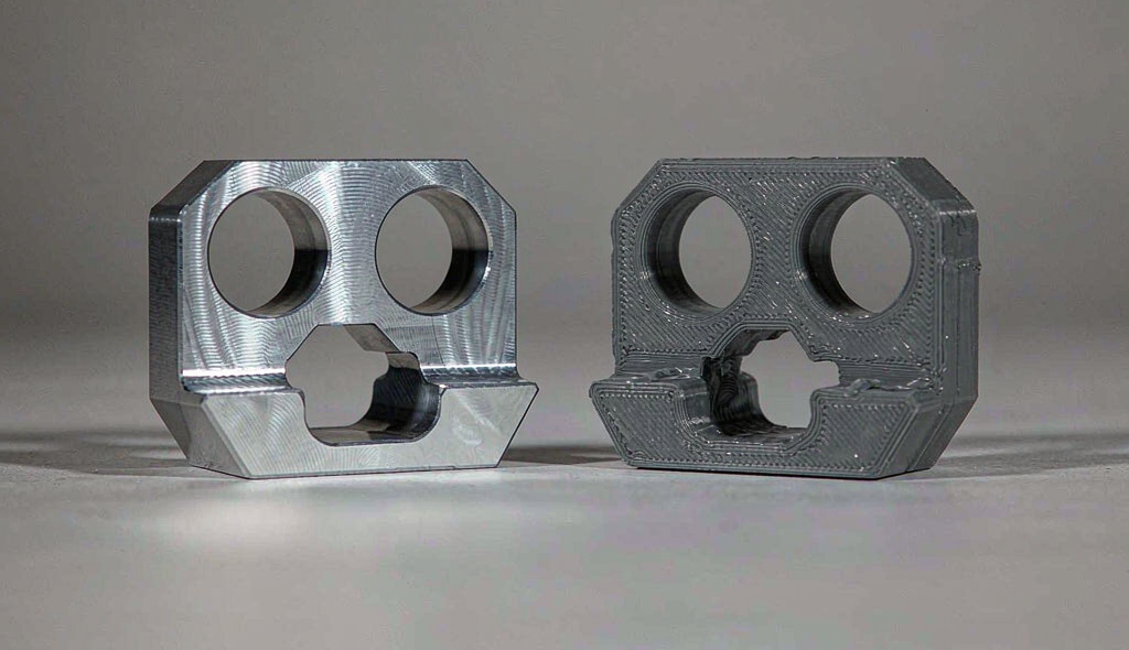 CNC machined aluminum prototype part on the left and a 3D printed resin part on the right, side by side for comparison