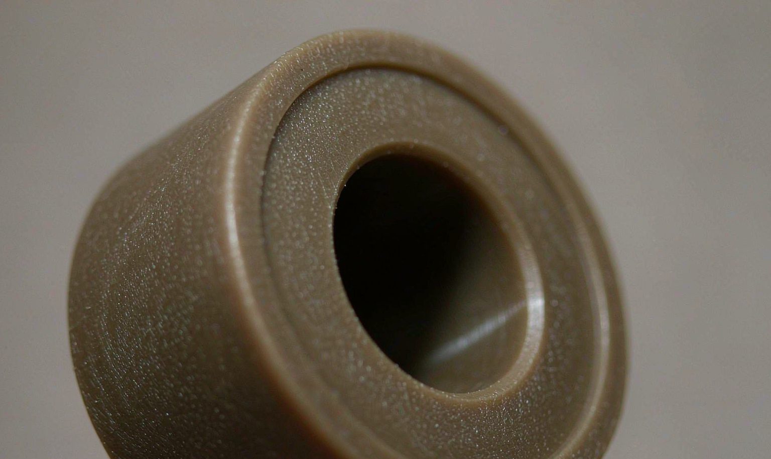 Close-up of a CNC machined nylon bushing with a precision inner bore