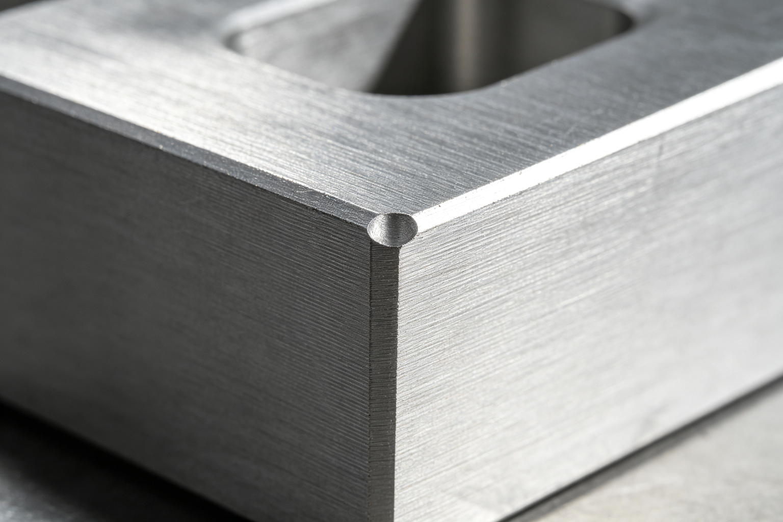 Machined internal corner on an aluminum bracket showing the small radius left by an end mill