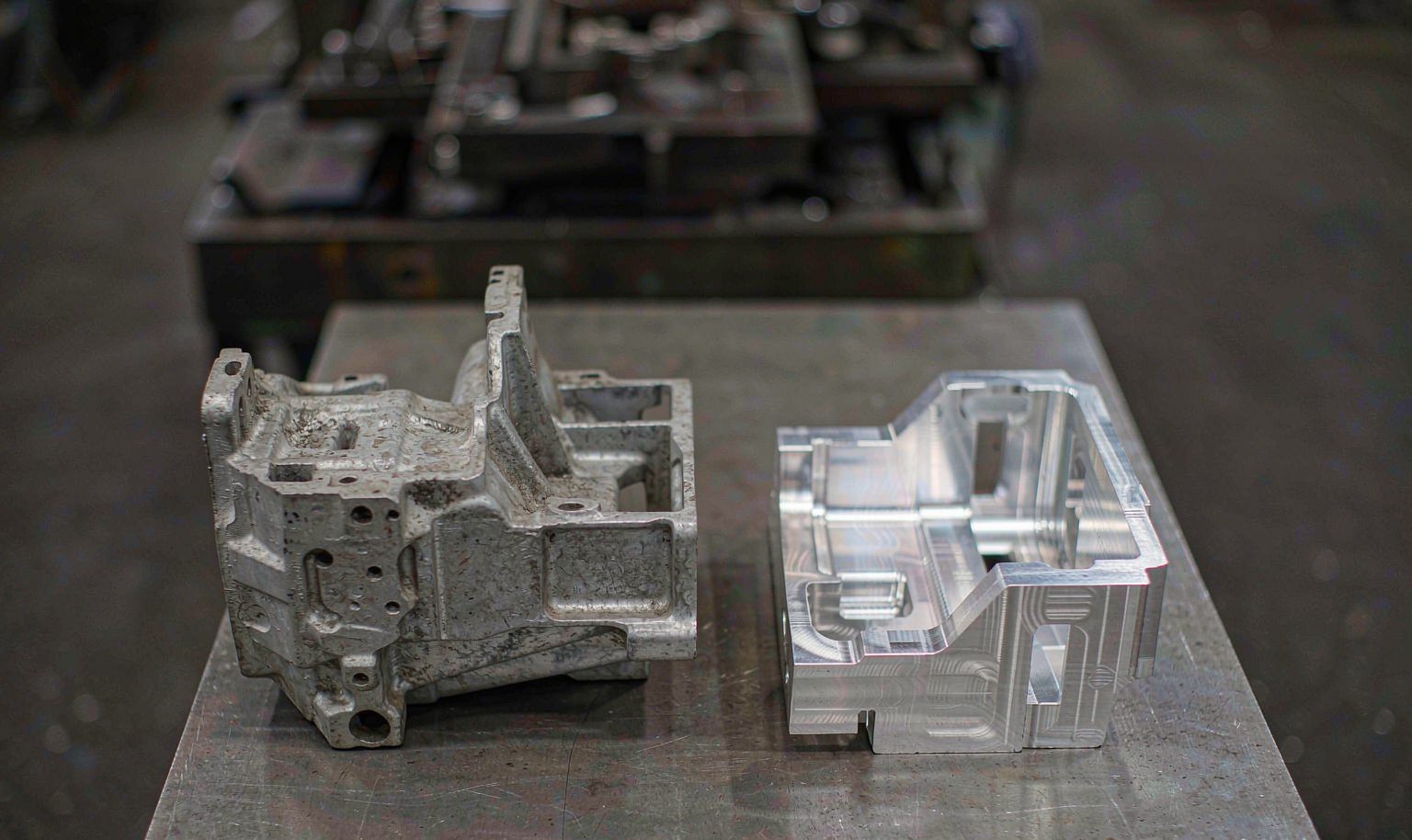A die cast aluminum part beside a CNC machined aluminum part for surface and tolerance comparison