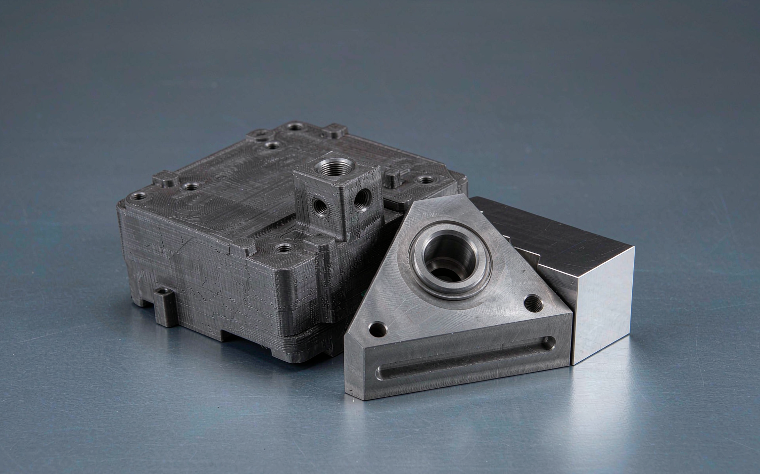 Hybrid AM plus CNC metal part showing 3D printed near-net-shape base with machined precision features