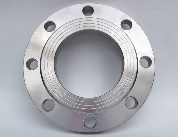 Assortment of freshly CNC machined alloy steel parts — shafts, gear blanks, pins, bushings and flanges — arranged on a heavy steel workbench