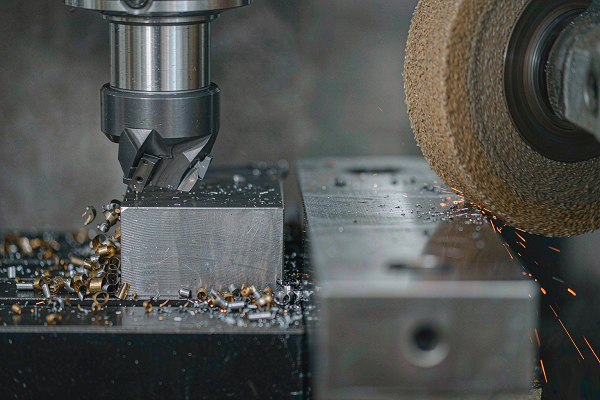 Side by side comparison of a CNC milling cutter removing chips from steel and an abrasive grinding wheel finishing a steel surface