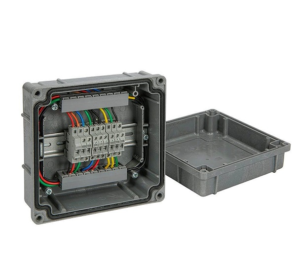 Inside of an IP68 box fitted with a metal DIN rail and grey terminal blocks with wiring