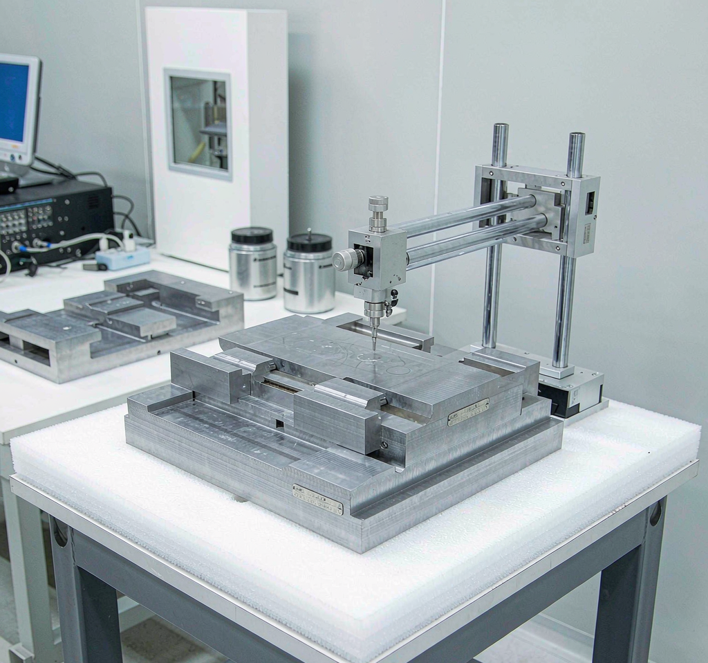Surface roughness tester measuring a flat machined medical component in a metrology room