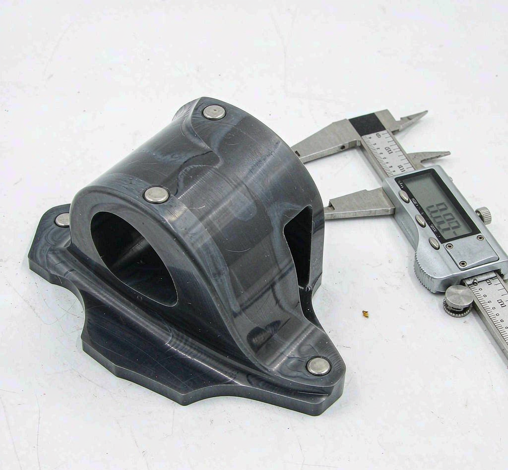 PEEK machined part being measured with a caliper during quality inspection