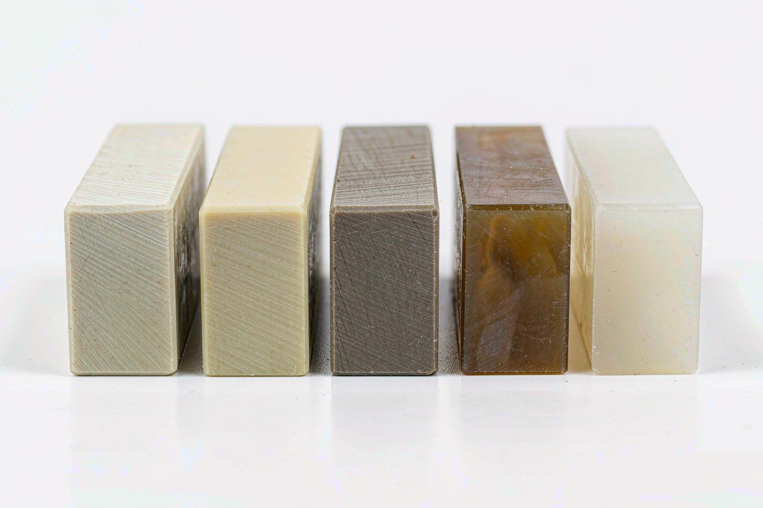 Row of engineering plastic material sample blocks in different colors showing milled faces
