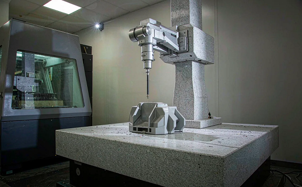 CMM inspecting a precision molded component on its granite table