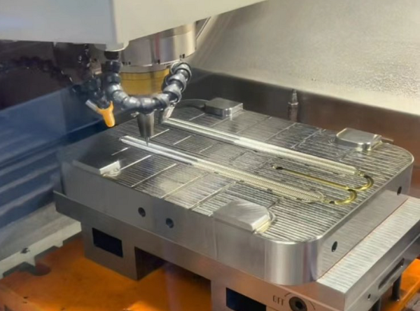 CNC machining centre cutting the cavity of an aluminium mold block with chips visible