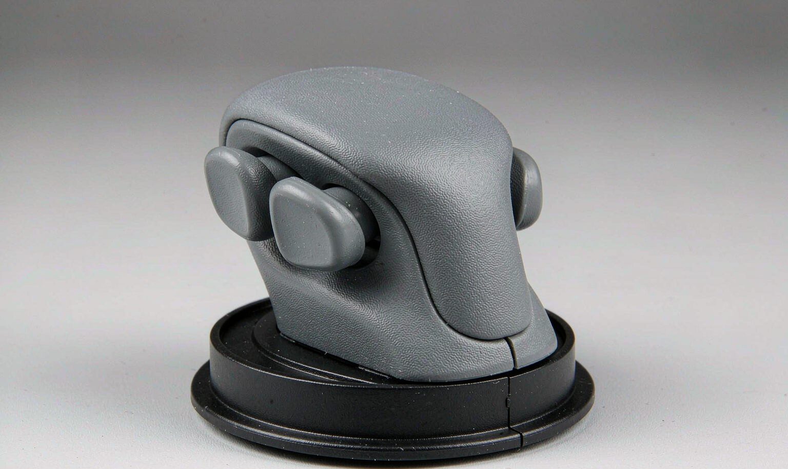 Two-shot molded part with a hard plastic base and a soft-touch elastomer overmold grip