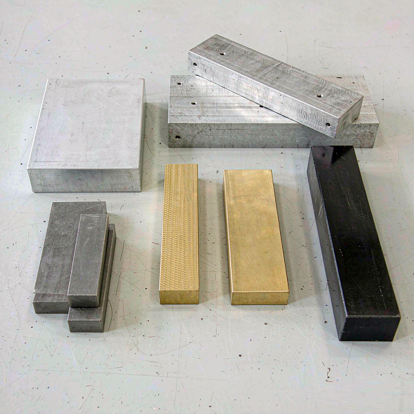 Selection of raw engineering stock: aluminium, stainless steel, brass, titanium and engineering plastic blocks