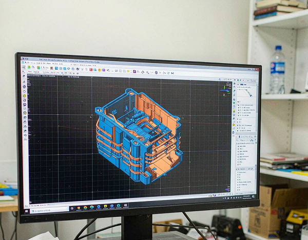 Manufacturing engineer reviewing a 3D CAD model of a plastic part during DFM analysis at Xiamen Goldcattle