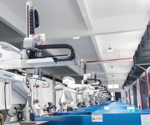 Robotic take-out arm removing moulded plastic parts from an injection moulding machine