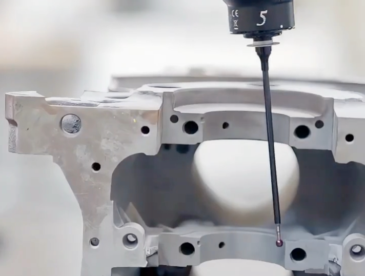 Coordinate measuring machine inspecting a precision machined part on a granite table