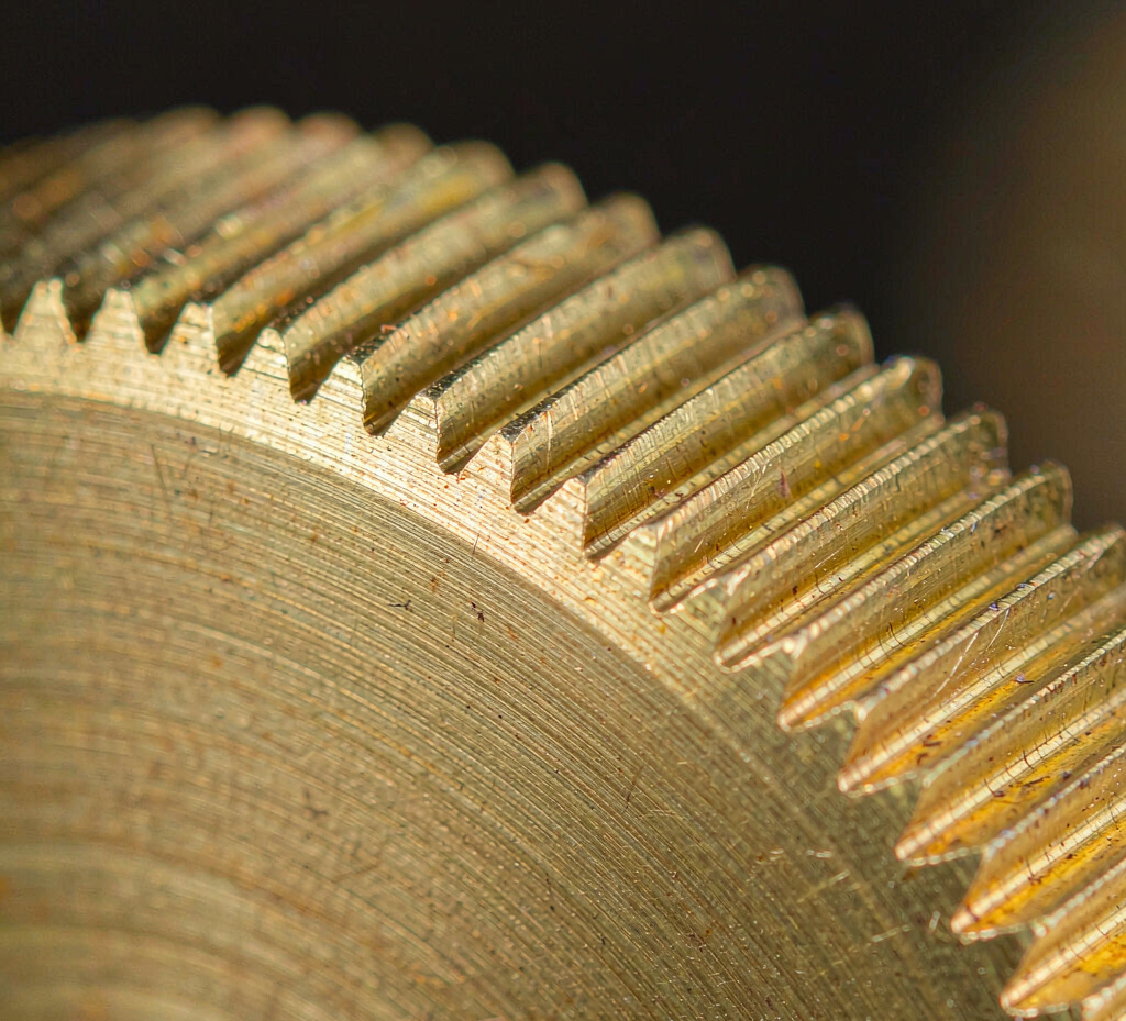 Macro view of a machined brass surface showing turning marks and a threaded feature