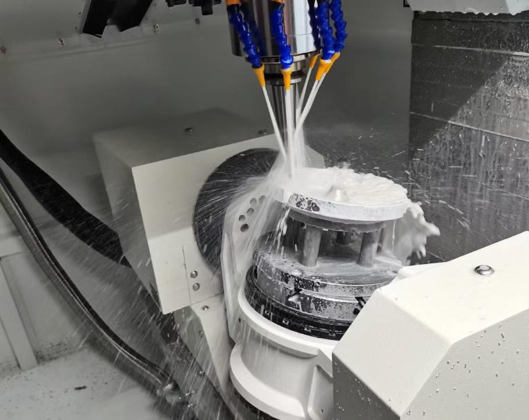 CNC machining centre cutting a metal part with metal chips and coolant around the cutting zone