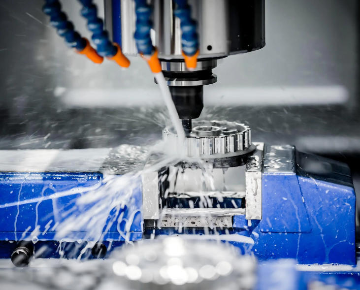 CNC machining center milling a metal block with flood coolant flowing over the cutting tool