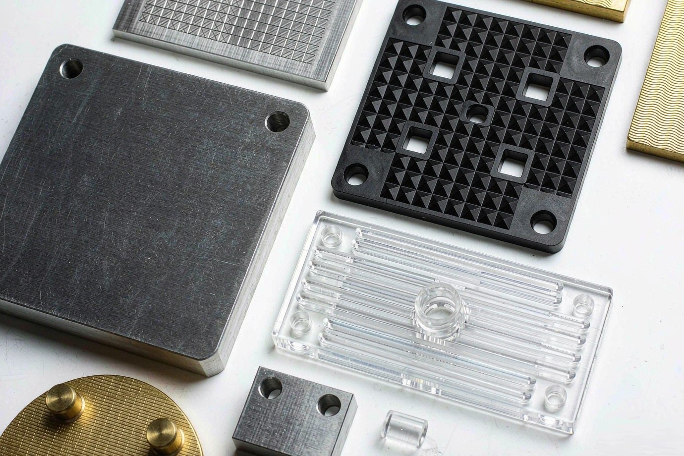 Illustrative — prototype parts in aluminum, ABS, polycarbonate and brass