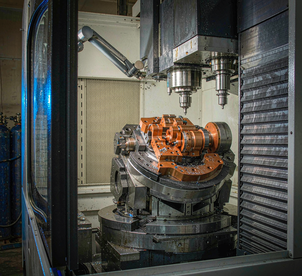 5-axis CNC machining center with a titanium part on a rotary tilt table