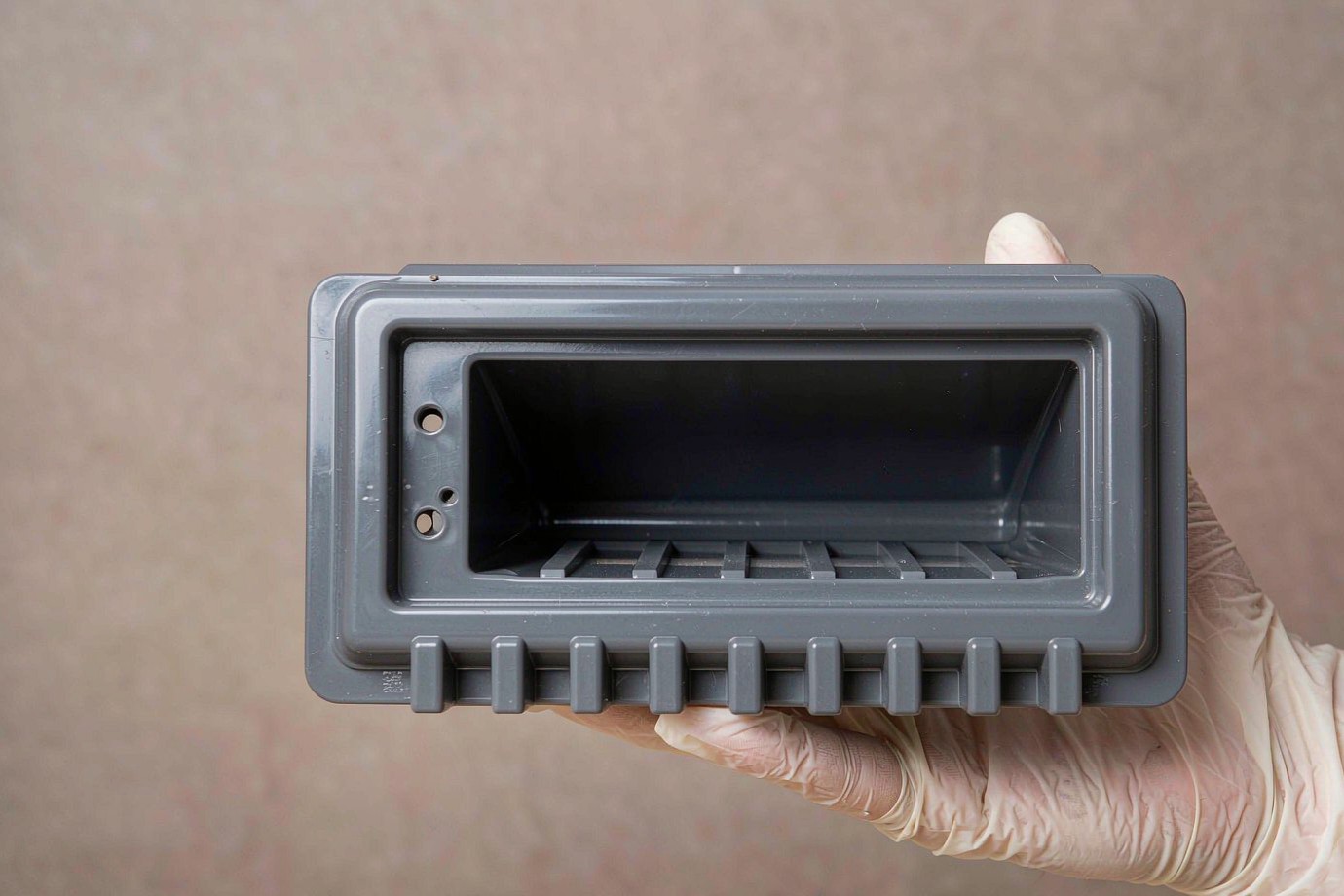 Illustrative molded appliance control-panel bezel with a recessed display window and button bosses