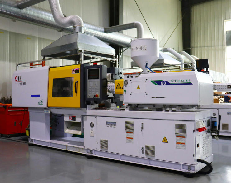 Illustrative — bright modern injection molding machine producing trays of freshly molded glossy appliance panels