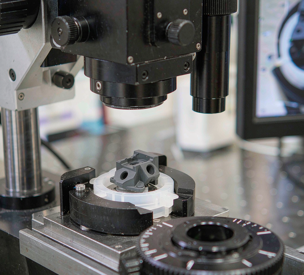 Dimensional inspection of a miniature molded plastic part on an optical measuring microscope in a quality lab