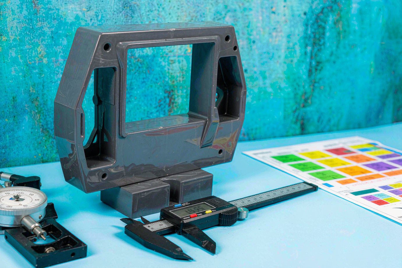 Illustrative — strong injection-molded bracket measured with digital calipers on a clean inspection bench