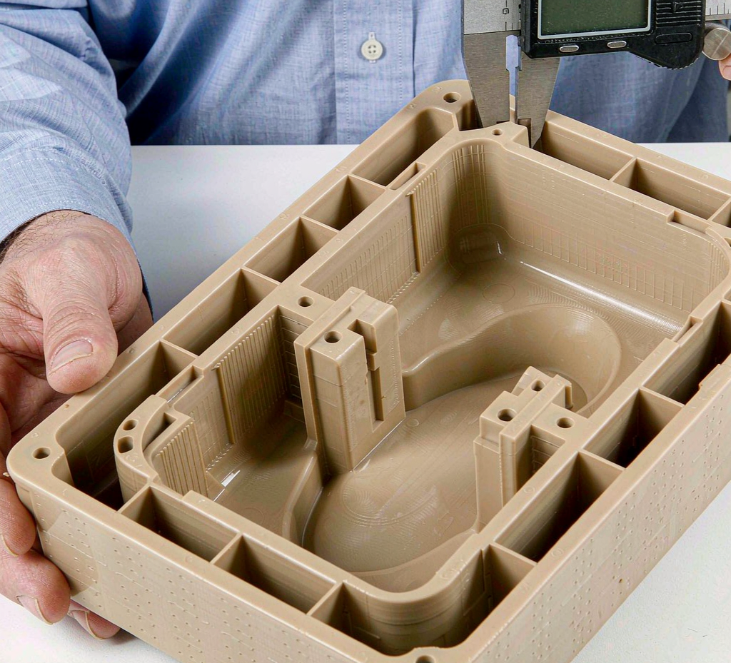 Digital caliper measuring a precision injection-molded packaging tray wall during inspection