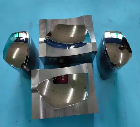 Molded plastic parts beside a polished steel injection mold half