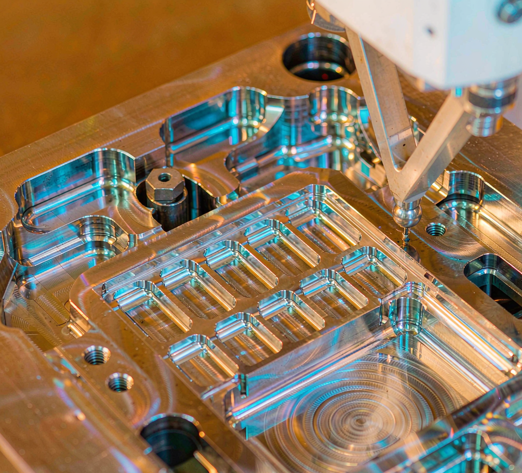 Polished steel mold cavity under CMM inspection with a touch probe