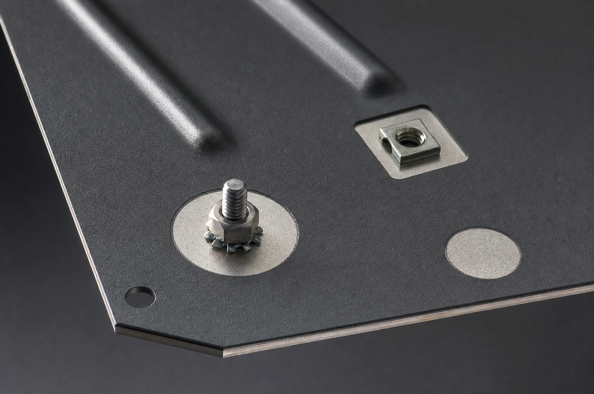 Powder-coated chassis panel with masked bare-steel grounding pads, a weld stud and a square clinch nut