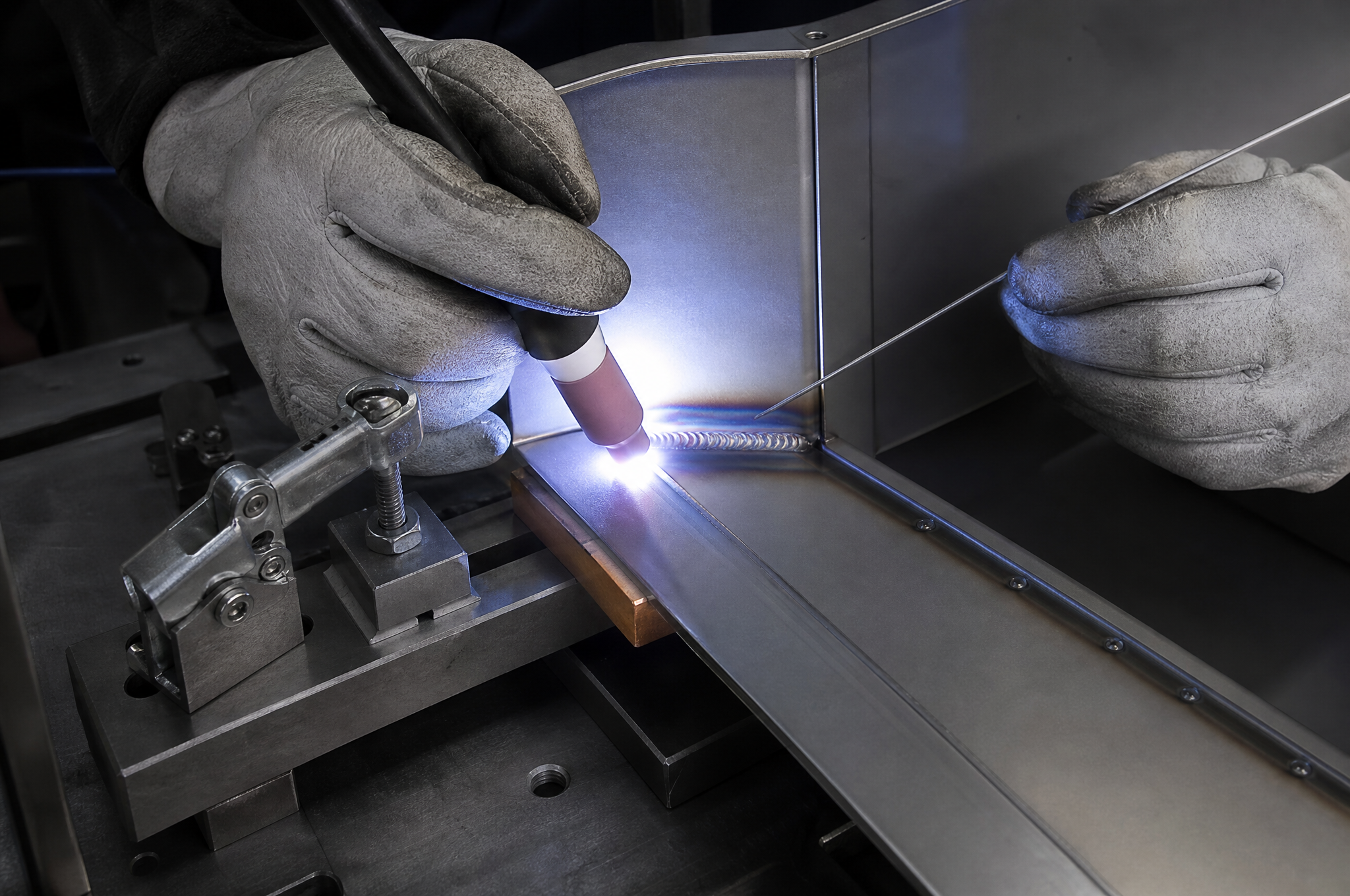 TIG welding the inside corner of a 1.5 mm cold-rolled steel chassis frame in a fixture with copper backing