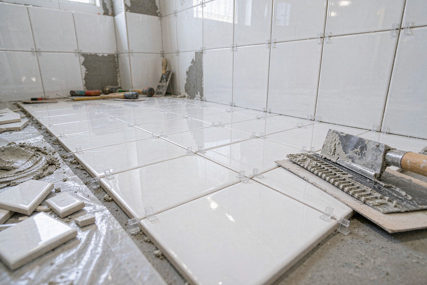 Illustrative — plastic cross spacers holding even grout joints during a ceramic tile installation