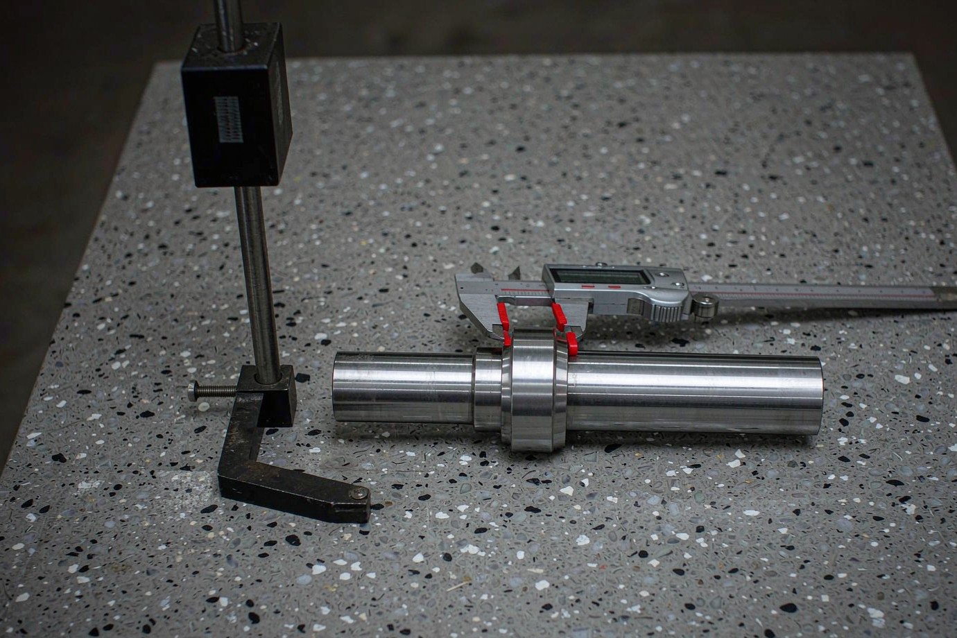 Inspection of a turned shaft with calipers on a granite plate