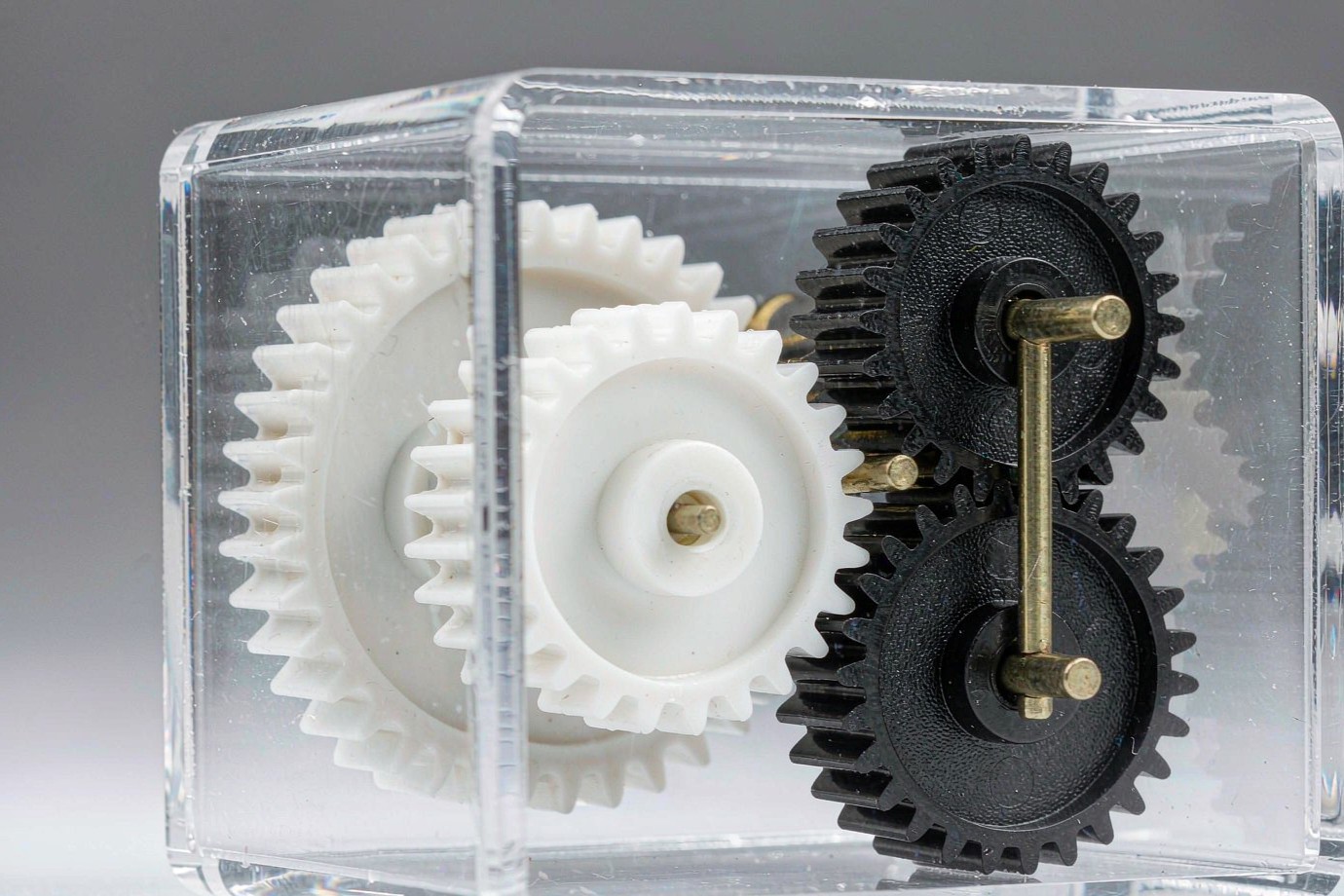 Molded plastic gears meshed inside a transparent device housing, showing a small gear train (Illustrative)