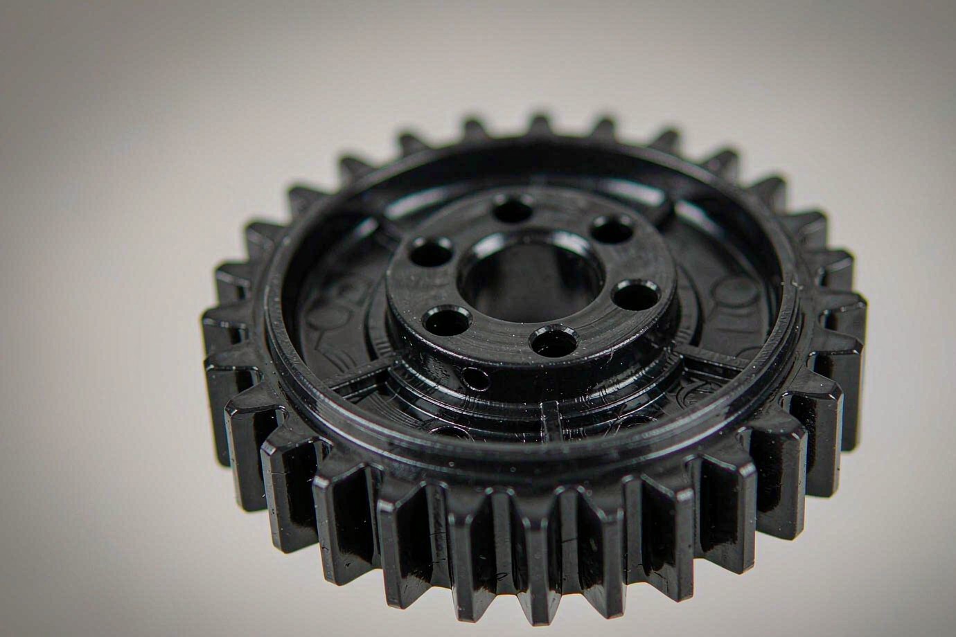 Macro view of a molded plastic gear showing tooth profile and molded surface finish (Illustrative)