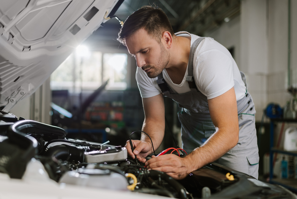 Auto mechanic working on car