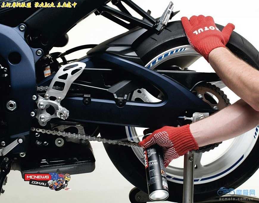 Mechanic adjusting motorcycle chain tension